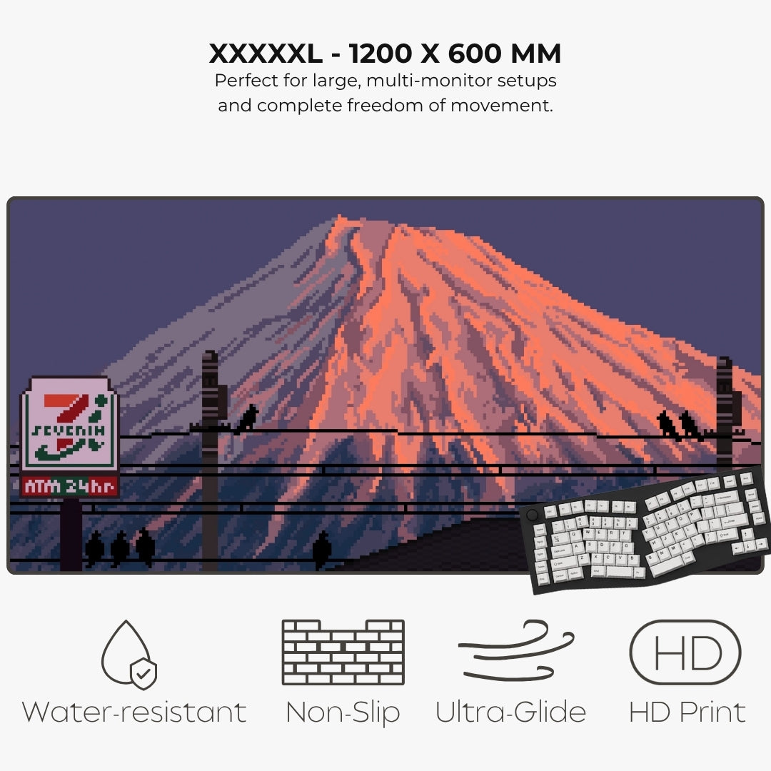 A large pixel-art style mousepad of a Mount Fuji with a glowing orange peak, dark blue sky, utility poles, birds, and a 7-Eleven sign, shown on a light gray background.