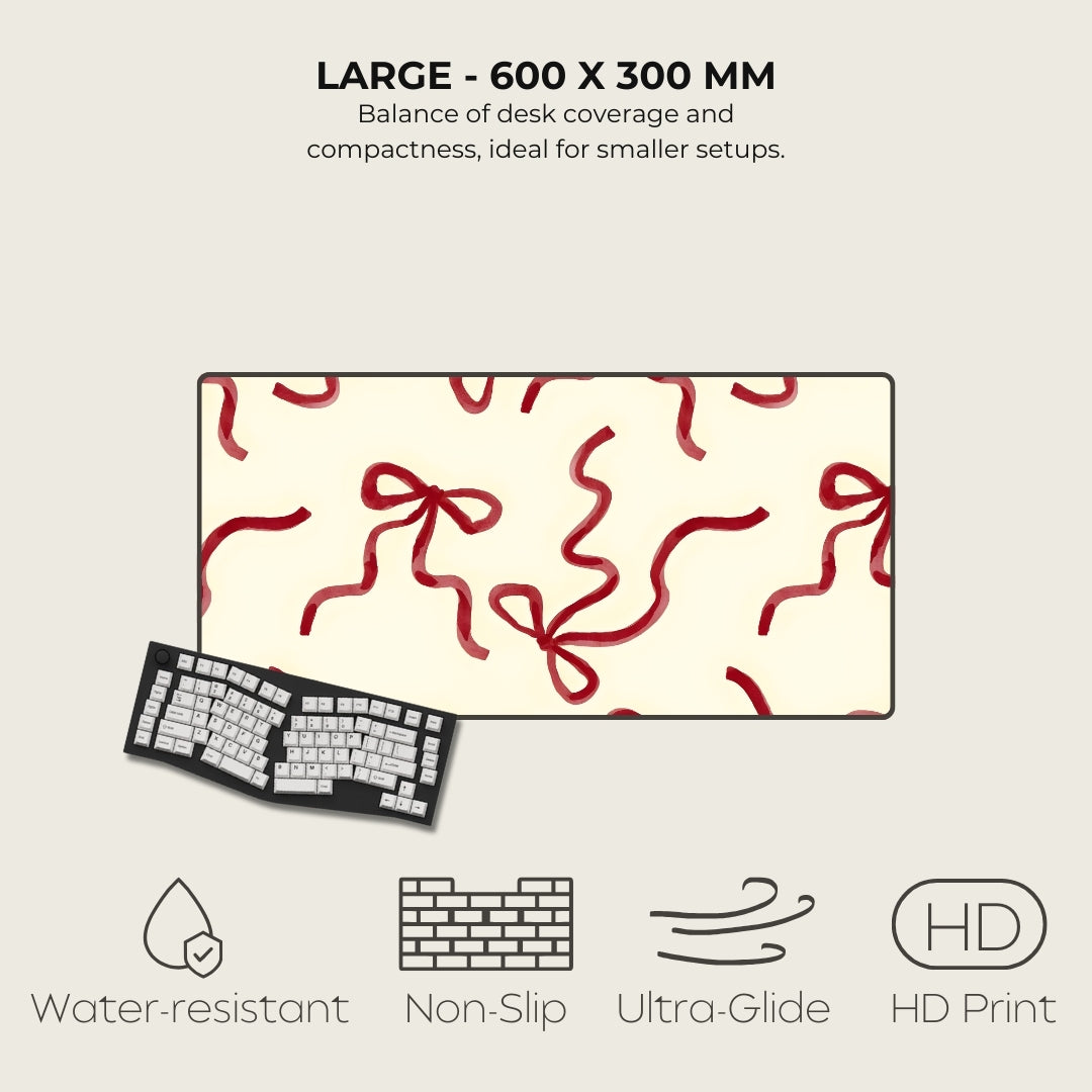 Large desk mat with red ribbon pattern, keyboard below, and feature icons on a light gray background.