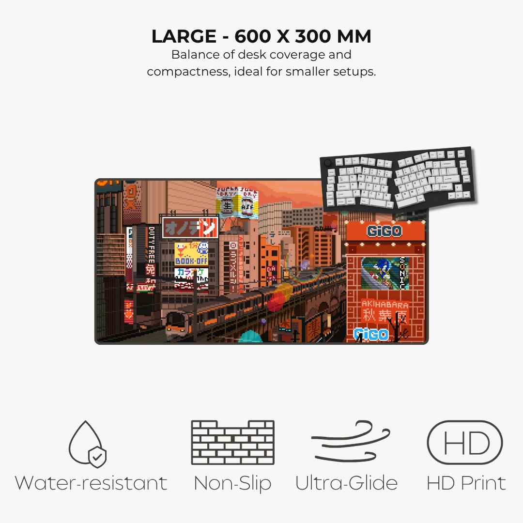 A large desk mat featuring a detailed city street scene with trains, signs, and storefronts, shown on a light gray background with text highlighting its size and features like water resistance, non-slip grip, and ultra-glide surface.