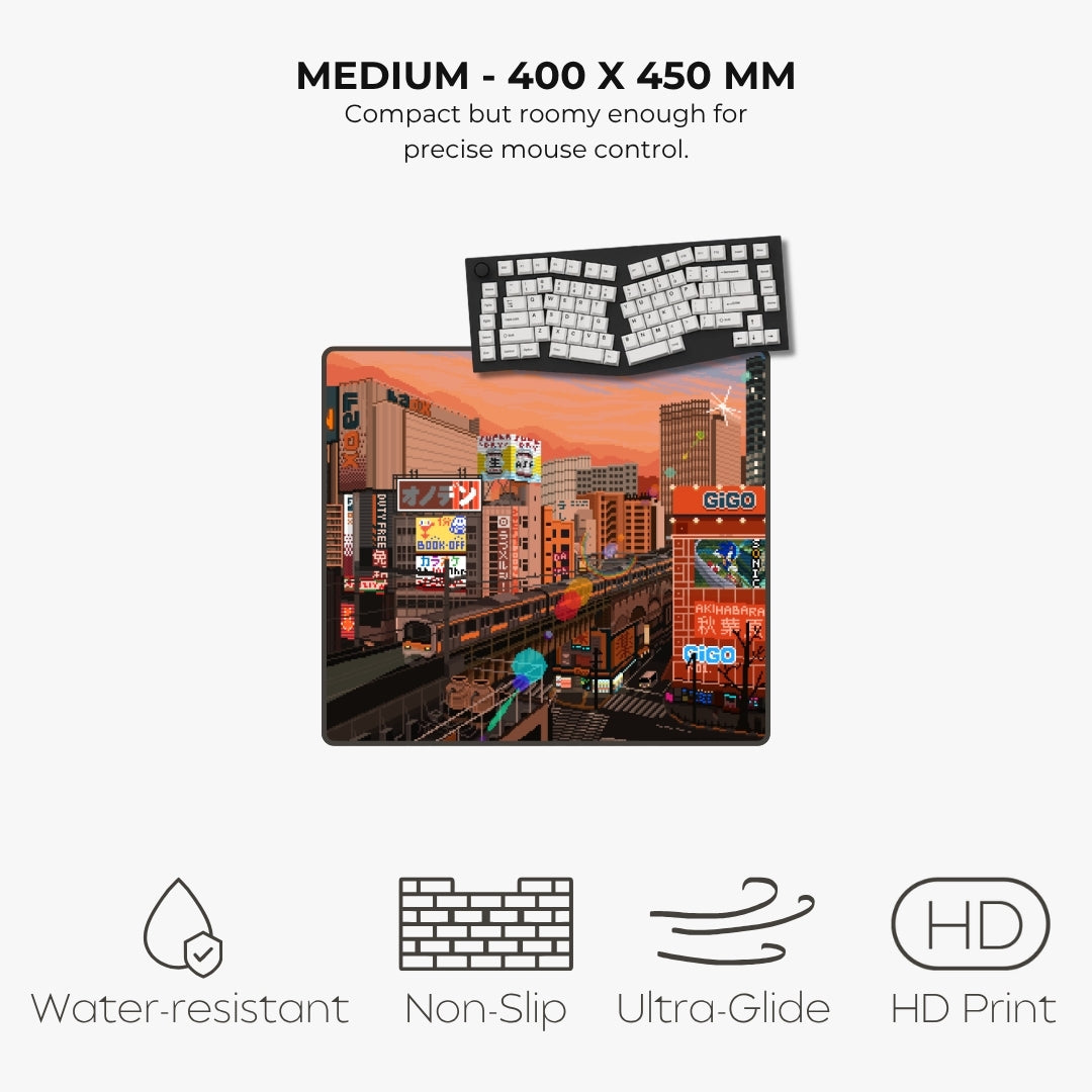 A product listing graphic for a medium-sized desk mat featuring a colorful city street scene print. The mat is shown with a small floating keyboard illustration above it, along with marketing text reading 'MEDIUM - 400 X 450 MM' and feature icons for water resistance, non-slip texture, ultra-glide surface, and HD print
