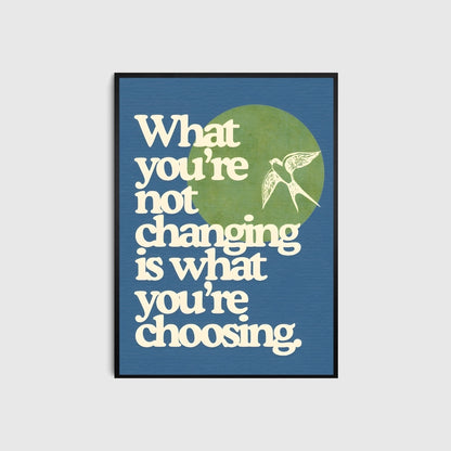 Framed poster with motivational quote 'What you're not changing is what you're choosing' on a blue background.