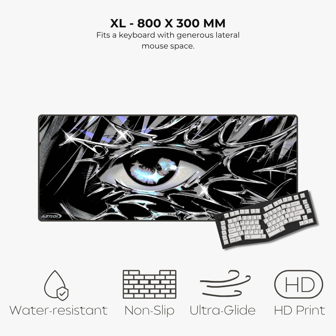 A large rectangular gaming mouse pad with a black, white, and gray abstract eye design, shown with a keyboard on a light gray background. Text above reads 'XL - 800 X 300 MM' and text below lists features: water-resistant, non-slip, ultra-glide, and HD print.
