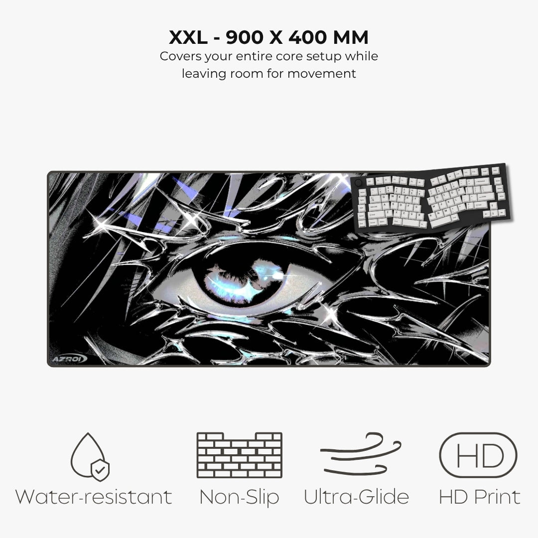 A large rectangular gaming mouse pad with a black, white, and gray anime-style eye graphic, shown on a light gray background with text reading 'XXL - 900 X 400 MM' and feature icons for water resistance, non-slip, ultra-glide, and HD print.