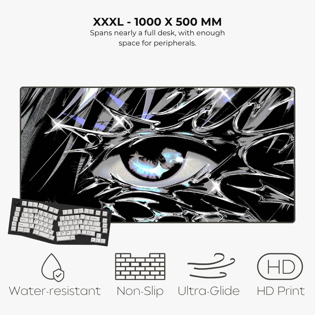 A large rectangular gaming desk mat with a black-and-white anime-style eye graphic and a keyboard shown on top, with text reading 'XXXL - 1000 X 500 MM' and feature icons for water-resistant, non-slip, ultra-glide, and HD print.