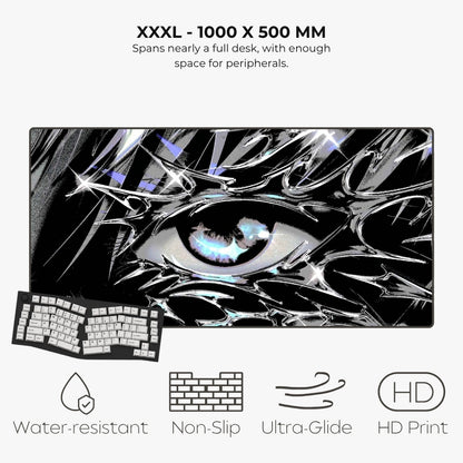 A large rectangular gaming desk mat with a black-and-white anime-style eye graphic and a keyboard shown on top, with text reading 'XXXL - 1000 X 500 MM' and feature icons for water-resistant, non-slip, ultra-glide, and HD print.