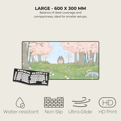 Large desk mat with cartoon design, featuring a cat-like creature and cherry blossoms, on a light gray background.