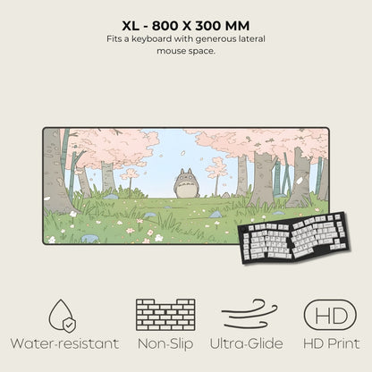 Large mouse pad with cartoon design featuring a cat-like creature, surrounded by trees and flowers, on a light beige background.