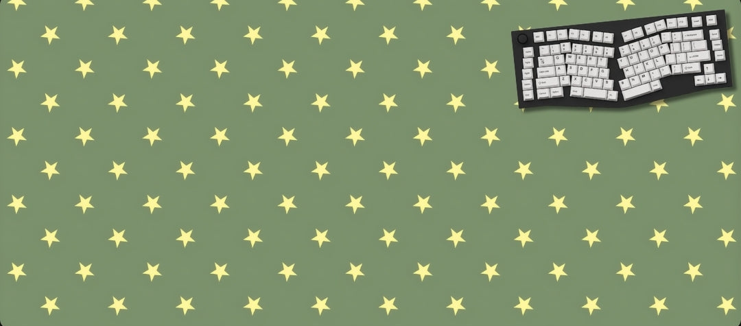 Green desk mat with yellow star pattern and a black keyboard on a green background