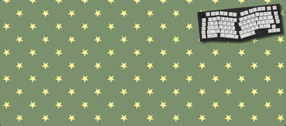 Green desk mat with yellow star pattern and a black keyboard on a green background