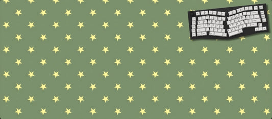Green desk mat with yellow star pattern and a black keyboard on a green background