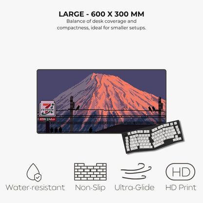A large desk mat featuring a pixel-art style illustration of Mount Fuji with a 7-Eleven sign, shown with text highlighting size, features, and icons for water resistance, non-slip grip, glide, and HD print.