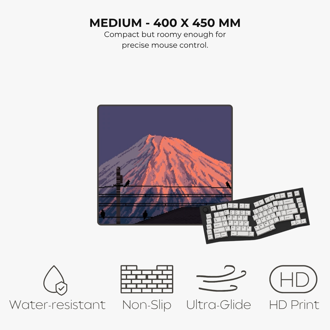 A product infographic showing a rectangular desk mat with a pixel art Fuji mountain print and a keyboard placed on top, with text reading 'MEDIUM - 400 X 450 MM' and feature icons for water-resistant, non-slip, ultra-glide, and HD print.