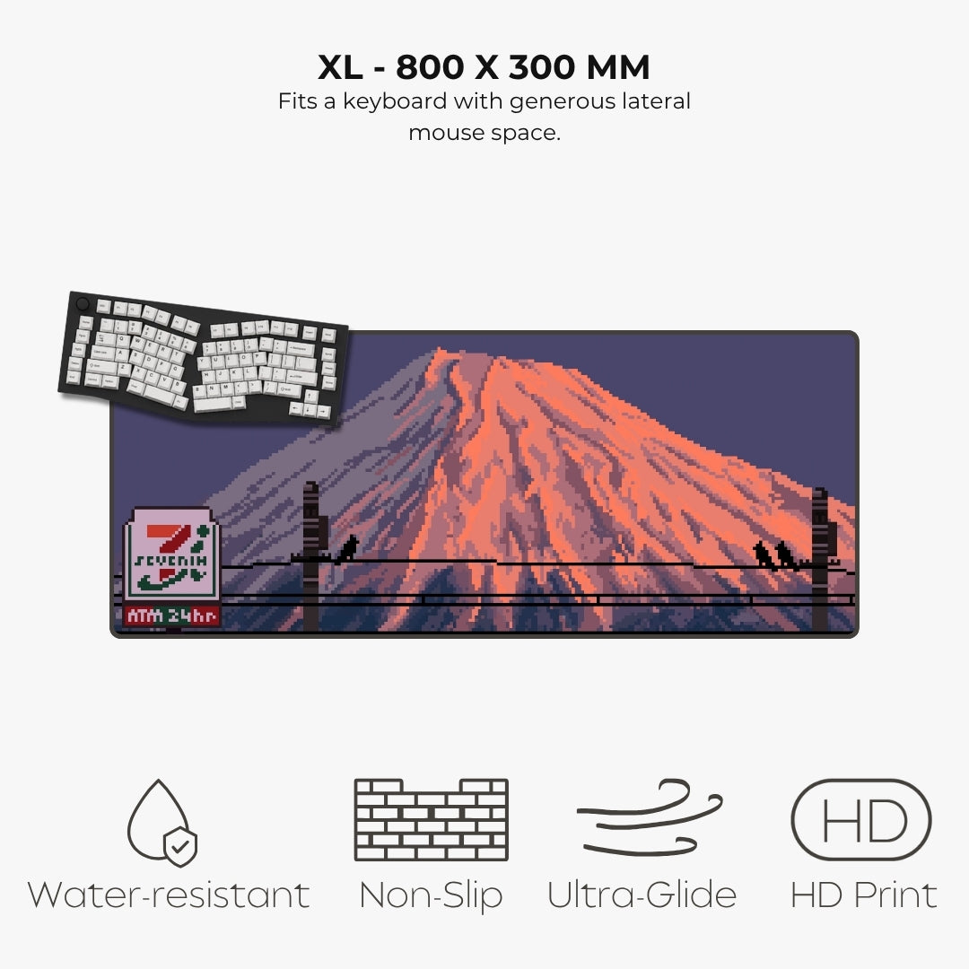 A variant for a large desk mat or mousepad featuring a pixel-art mount Fuji  scene. The image includes text stating 'XL - 800 X 300 MM' and 'Fits a keyboard with generous lateral mouse space,' plus feature icons and labels for water-resistant, non-slip, ultra-glide, and HD print qualities.