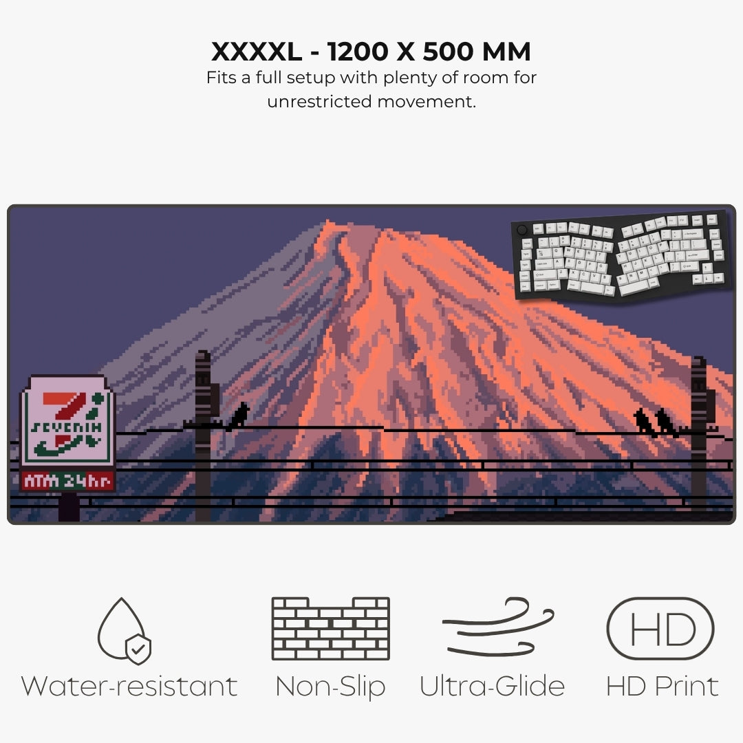 A mousepad listing  for a large pixel-art Mount fuji with a glowing orange peak, dark purple sky, power lines, a, a 7-Eleven sign, and feature callouts reading 'XXXXL - 1200 X 500 MM,' 'Fits a full setup with plenty of room for unrestricted movement,' 'Water-resistant,' 'Non-Slip,' 'Ultra-Glide,' and 'HD Print.