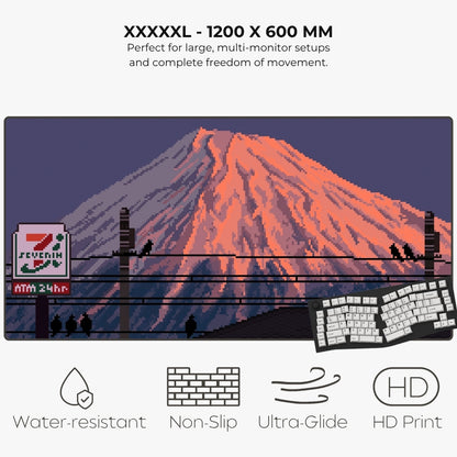 A large pixel-art style mousepad of a Mount Fuji with a glowing orange peak, dark blue sky, utility poles, birds, and a 7-Eleven sign, shown on a light gray background.