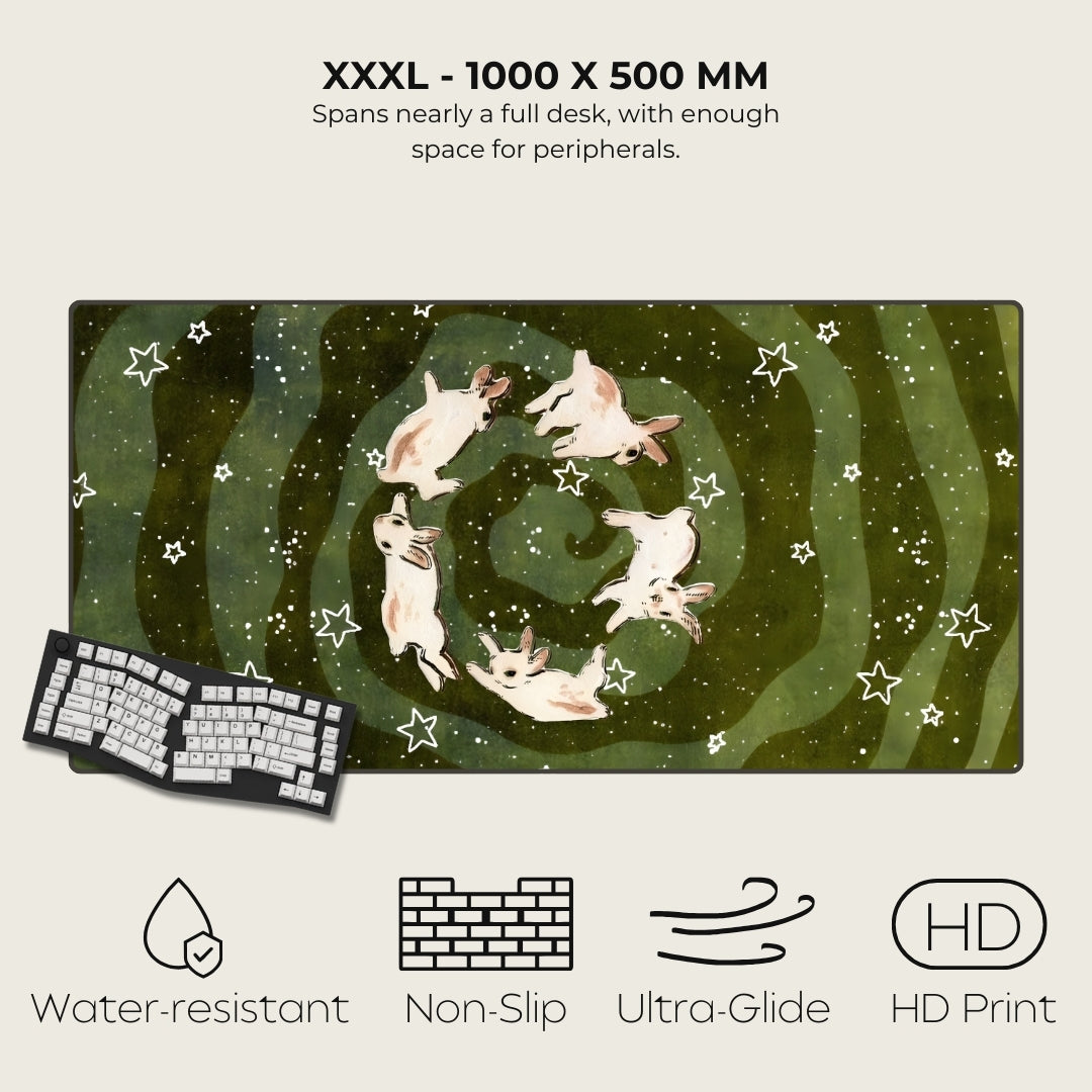 Large desk mat with rabbit design and product features on a white background