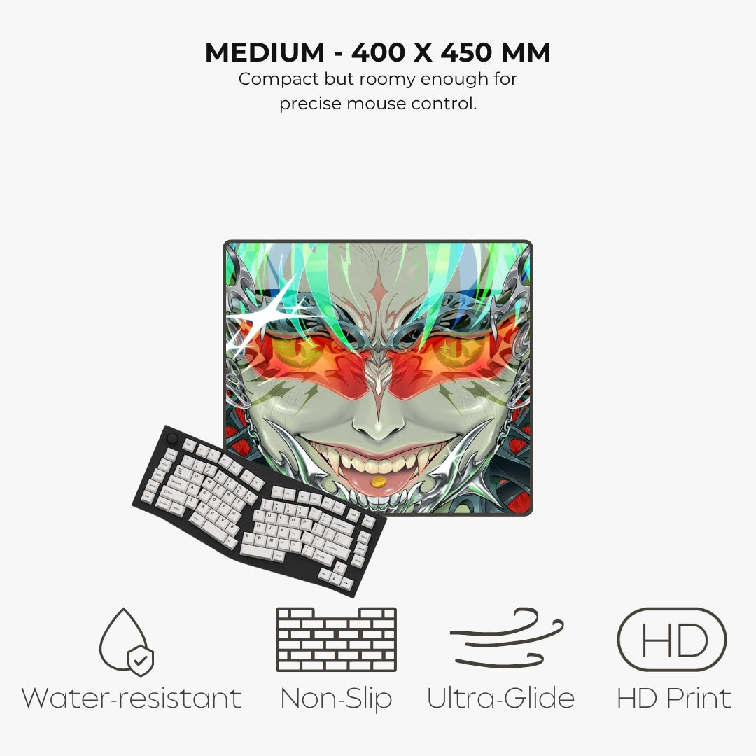 A compact gaming mouse pad with a colorful anime-style demon face graphic, shown with a matching black keyboard on a light gray background. Text above reads 'MEDIUM - 400 X 450 MM' and below feature icons for water-resistant, non-slip, ultra-glide, and HD print.