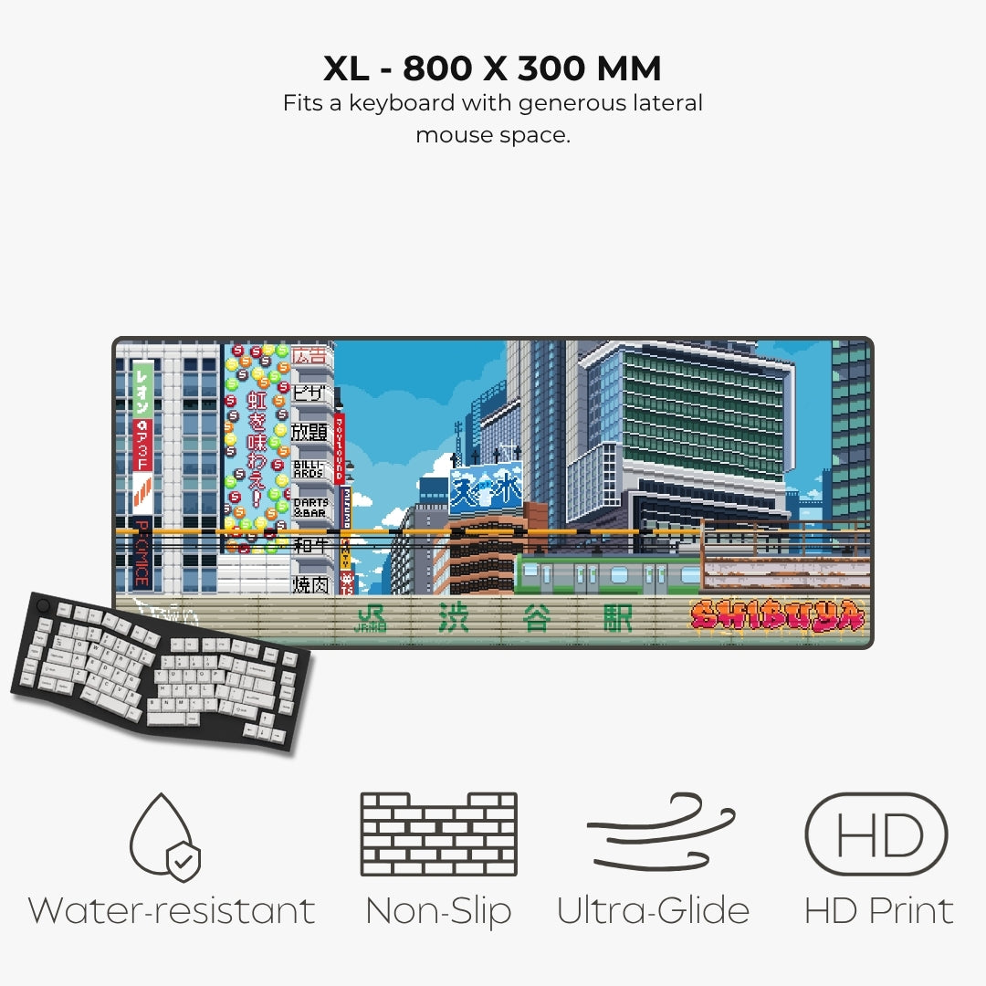 A rectangular gaming keyboard mat with a colorful Japanese cityscape print, shown on a light gray background with text and icons highlighting features: XL - 800 x 300 mm, water-resistant, non-slip, ultra-glide, and HD print. A small inset shows the keyboard underneath the mat.