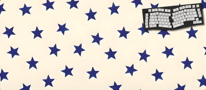 Beige desk mat with blue star pattern and a keyboard on a black background