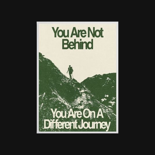 Motivational poster with silhouette of a person on a mountain and text 'You Are Not Behind, You Are On A Different Journey' on a beige background.