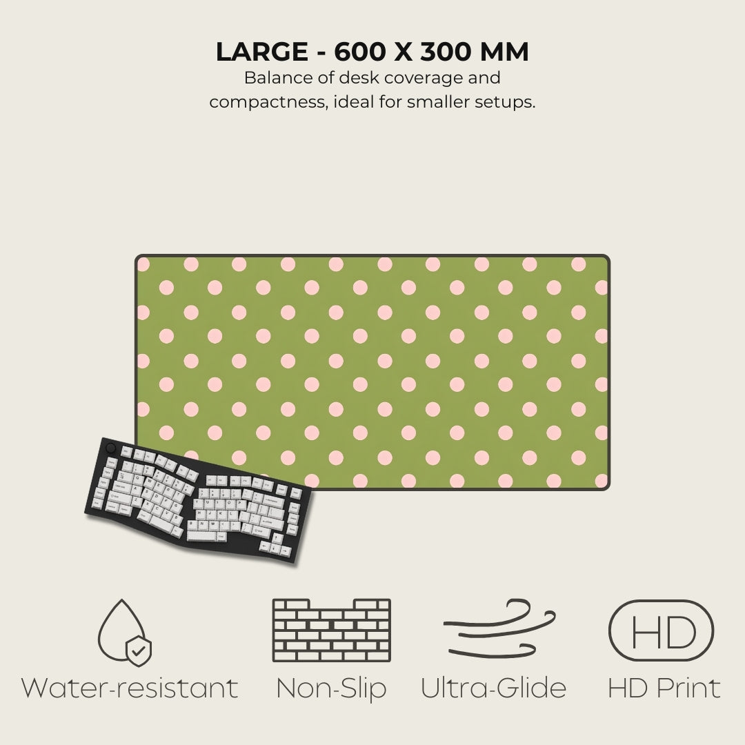 Green desk mat with pink polka dots and keyboard on a beige background