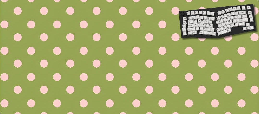 Green desk mat with pink polka dots featuring a keyboard design on a black background
