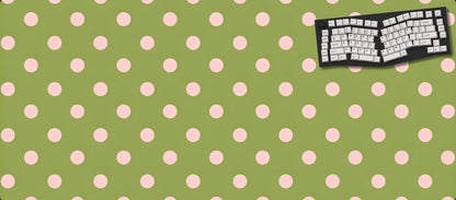 Green desk mat with pink polka dots featuring a keyboard design on a black background