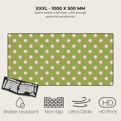 Green desk mat with pink polka dots, keyboard on the side, and feature icons below.