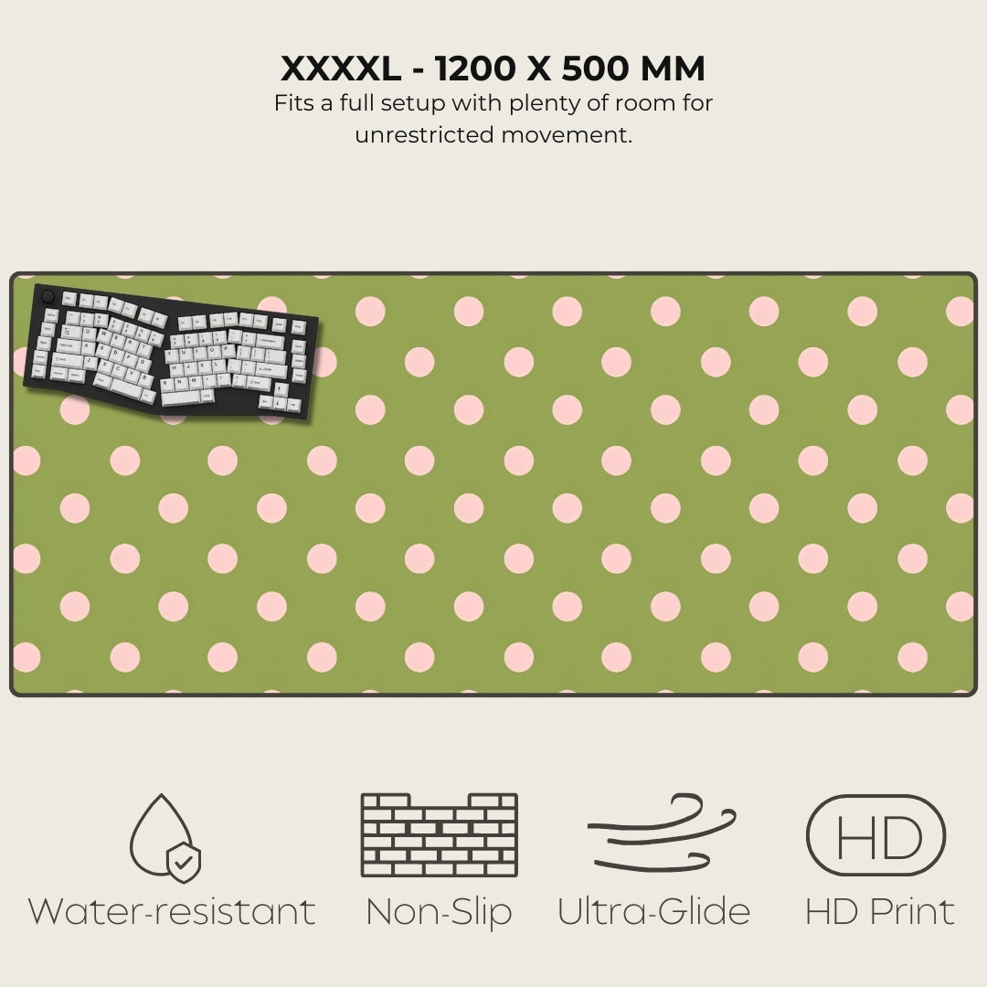 Green desk mat with pink polka dots featuring a keyboard on a white background