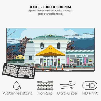 A product infographic for a large desk mat or desk pad featuring a pixel-art illustration of a Japanese street scene. The text at the top reads 'XXXL - 1000 X 500 MM' and describes its size.