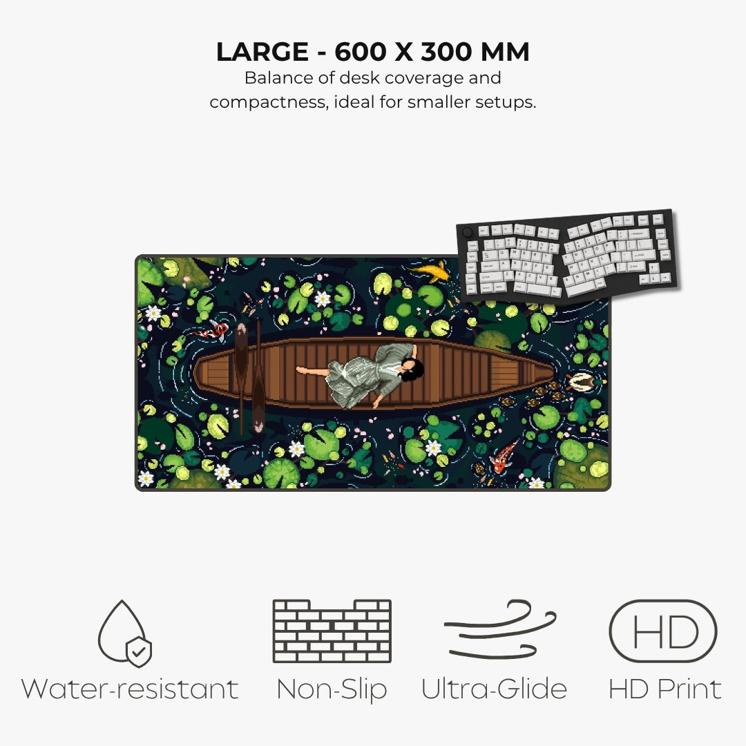 A large desk mat featuring an illustrated pond scene with lily pads, koi fish, and a person rowing a boat, shown on a light gray background with text reading 'LARGE - 600 X 300 MM' and feature icons for water resistance, non-slip, ultra-glide, and HD print.