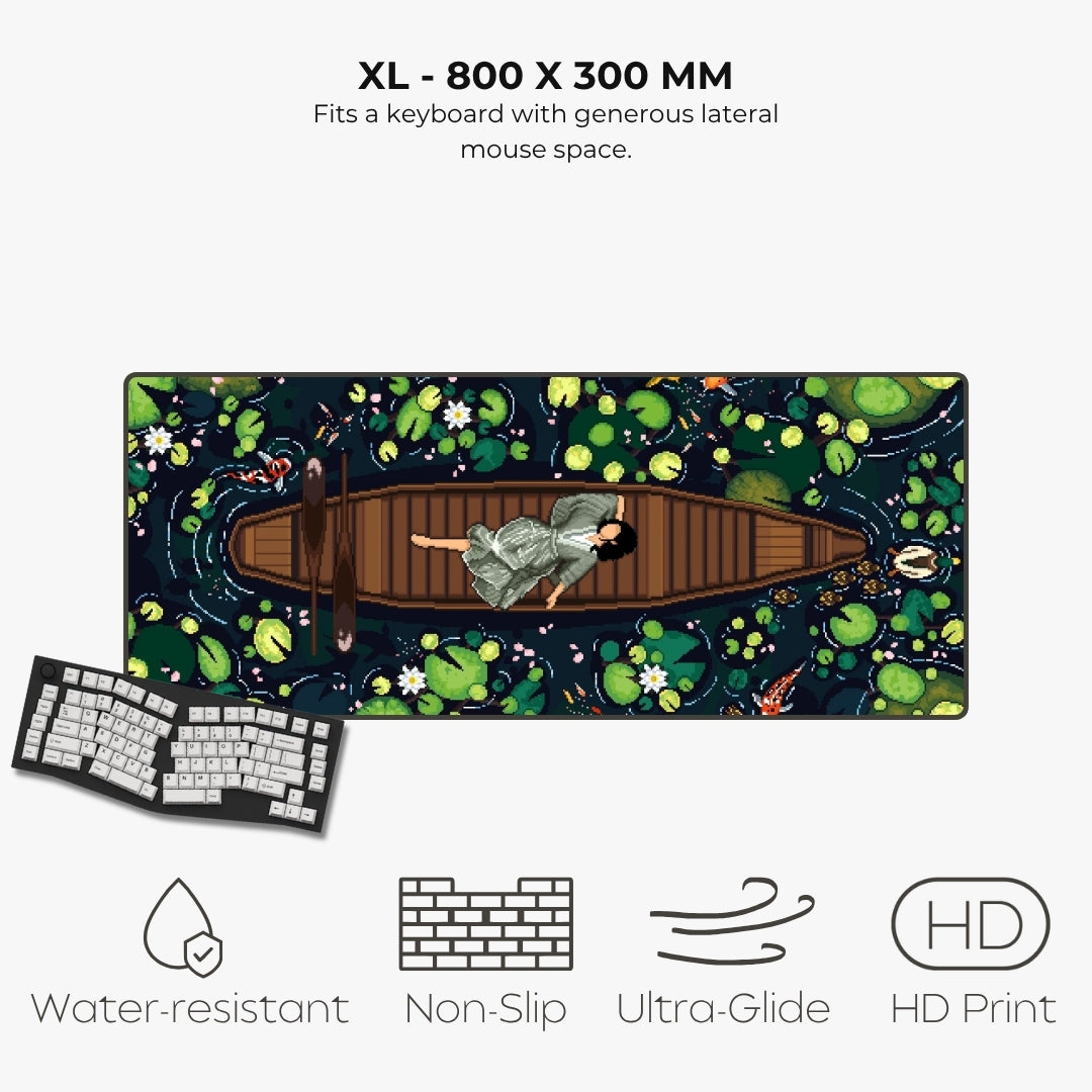 An XL keyboard mat with a detailed illustration of a woman in a boat on a pond, shown with a keyboard prop and text highlighting its features: 800 x 300 mm size, water-resistant, non-slip, ultra-glide, and HD print.