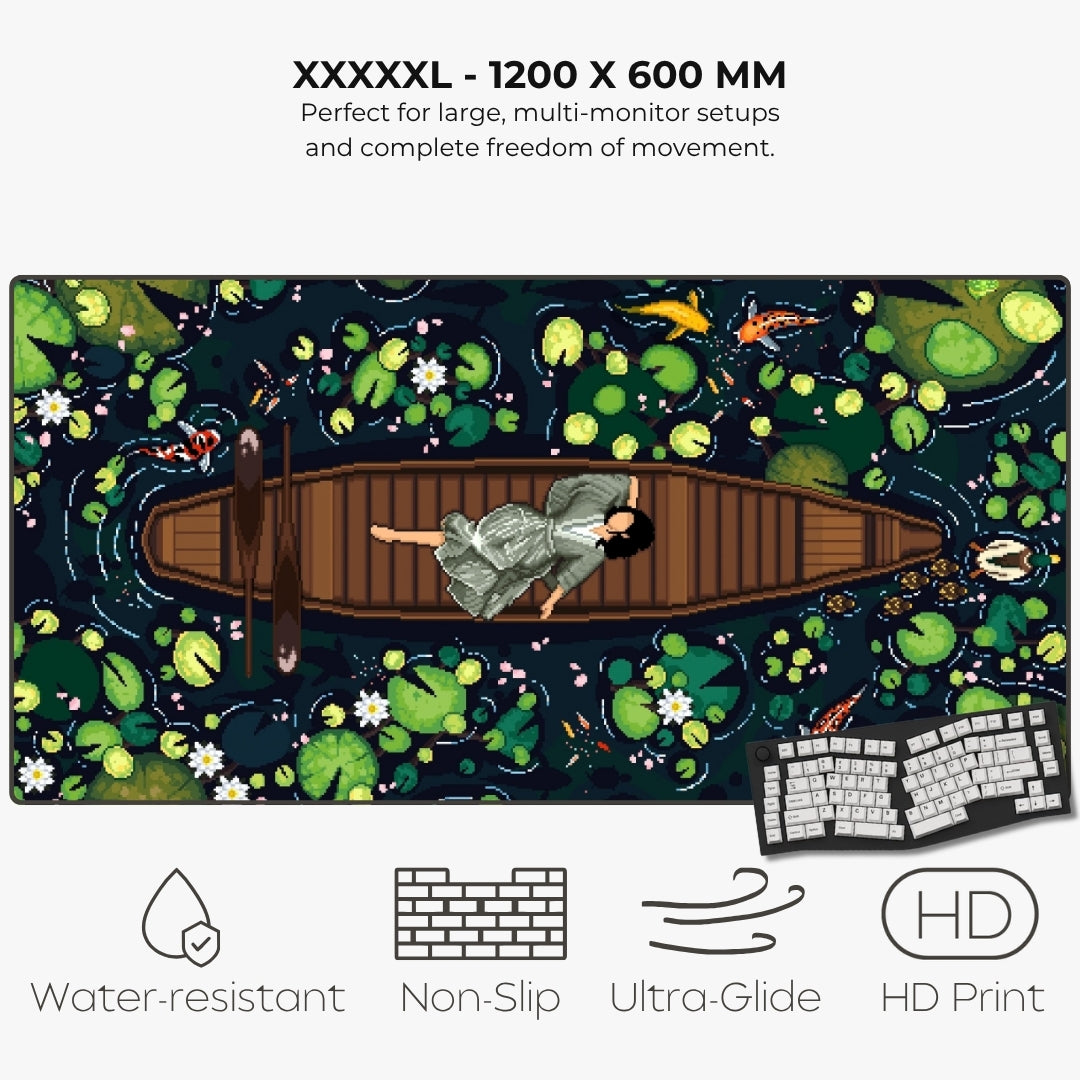 A large rectangular gaming mat with a pixel-art style pond scene, featuring a person in a boat surrounded by lily pads and fish. Text at the top reads 'XXXXL - 1200 X 600 MM' and describes large multi-monitor setup compatibility.