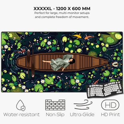A large rectangular gaming mat with a pixel-art style pond scene, featuring a person in a boat surrounded by lily pads and fish. Text at the top reads 'XXXXL - 1200 X 600 MM' and describes large multi-monitor setup compatibility.