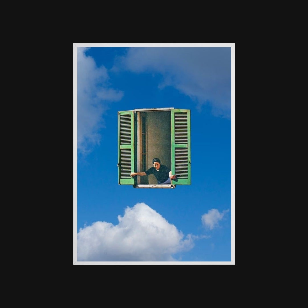Person sitting inside a green window frame against a blue sky with clouds