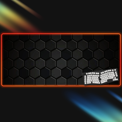 Black hexagonal patterned mouse pad with rgb border and keyboard on a dark background