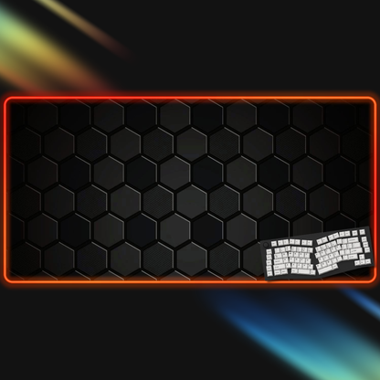 Gaming keyboard on a black hexagonal patterned mouse pad with rgb border
